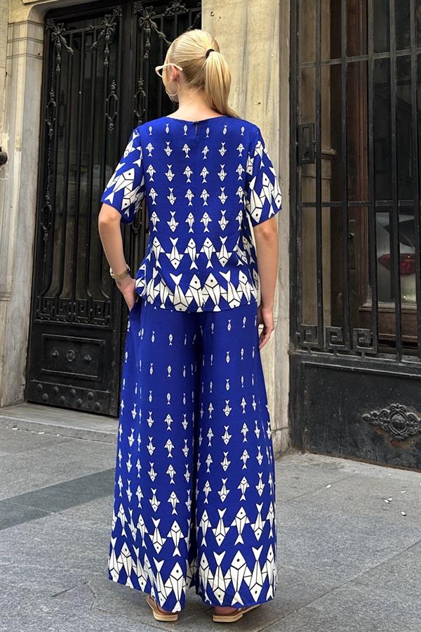 Saks mavisi, beyaz balık desenli, kayık yaka bluz ve bol paça pantolondan oluşan ikili takım.
