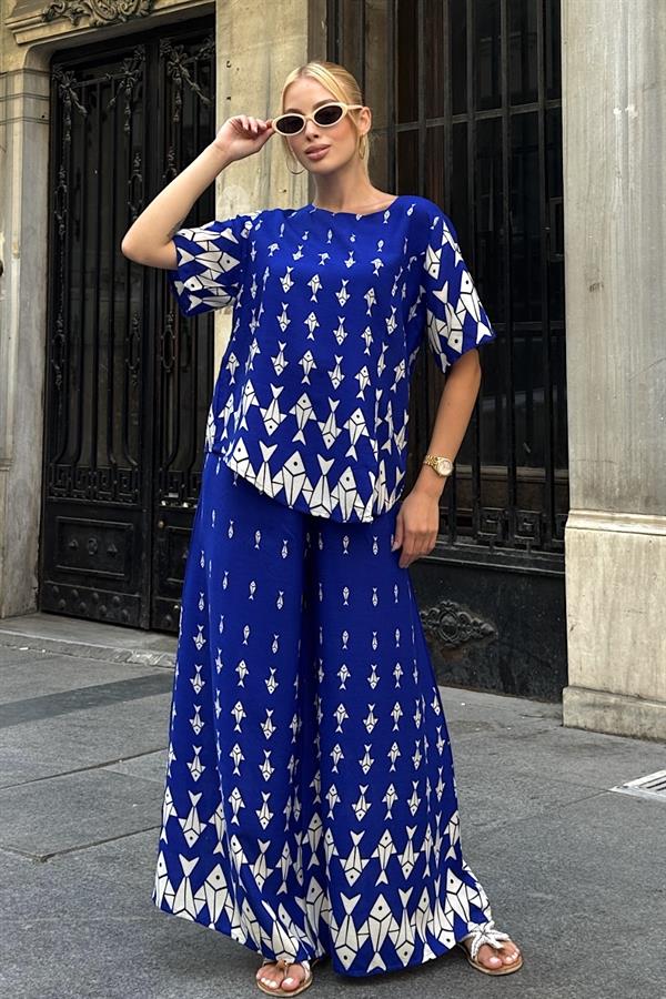 Saks mavisi balık desenli, kayık yaka bluz ve bol paça pantolondan oluşan ikili takım.