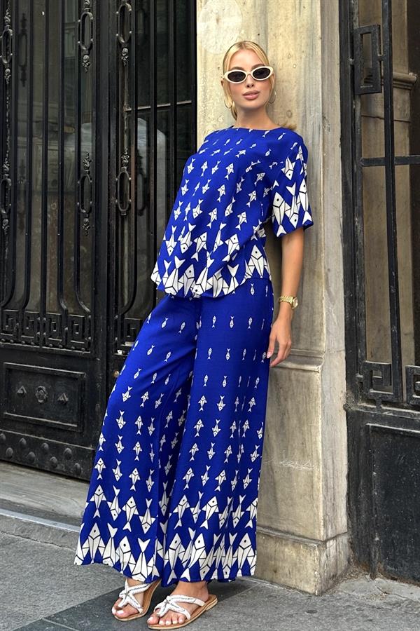 Saks mavisi, beyaz balık desenli, kayık yaka bluz ve bol paça pantolondan oluşan ikili takım.