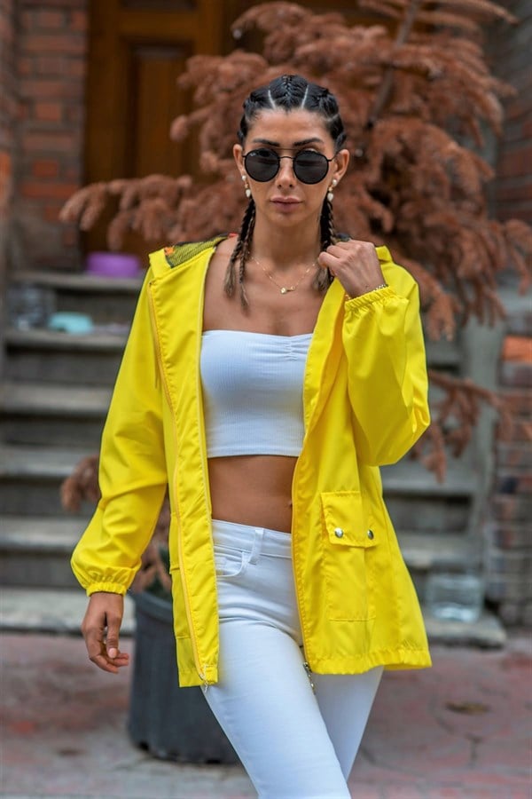 Sarı renkli, kapüşonlu, fermuarlı ve cepli ince kadın yağmurluk.