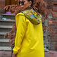 Sarı renkli, yıldız desenli kapüşonu olan, fermuarlı ve cepli ince yağmurluk.