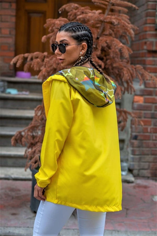 Sarı renkli, yıldız desenli kapüşonu olan, fermuarlı ve cepli ince yağmurluk.