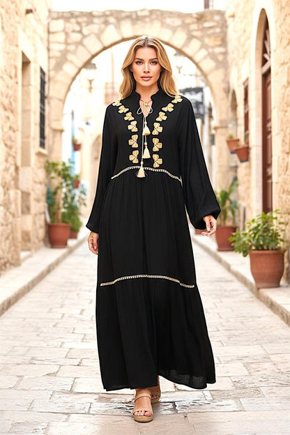 Siyah, balon kollu, önü yonca nakışlı ve püskül detaylı, kat kat uzun viskon elbise.