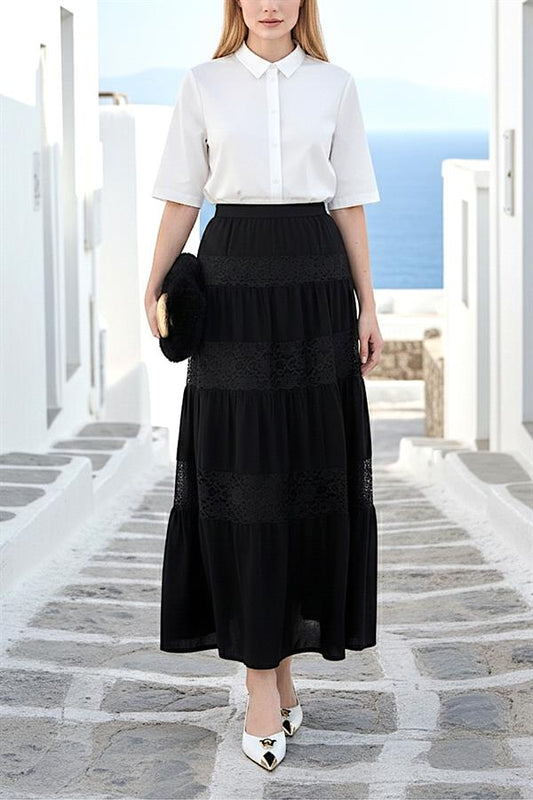 Beyaz gömlek ile kombinlenmiş, dantel detaylı, kat kat siyah uzun etek.