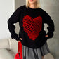 Siyah zemin üzerinde kırmızı kabartmalı büyük kalp desenli triko kazak.