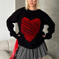 Siyah zemin üzerinde kırmızı kabartmalı büyük kalp desenli triko kazak.