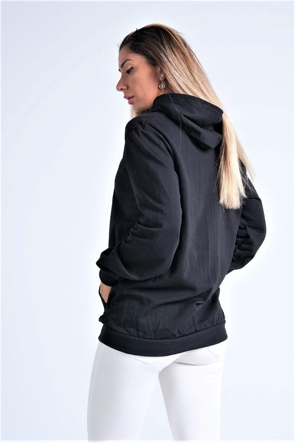 Siyah renkli, kapüşonlu ve kanguru cepli şardonlu sweatshirt giyen bir kadın.