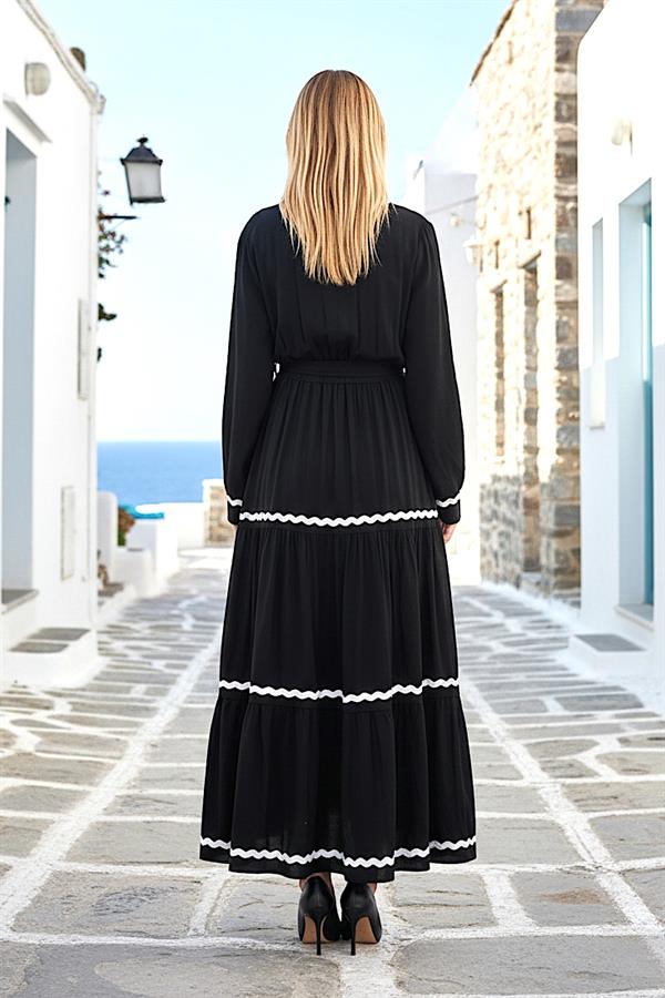 Siyah renkli, beyaz dalgalı şerit detaylı, uzun kollu ve kat kat etekli viskon elbise.