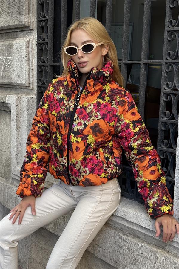 Turuncu zemin üzerine renkli çiçek desenli, dik yakalı ve fermuarlı kısa şişme mont.