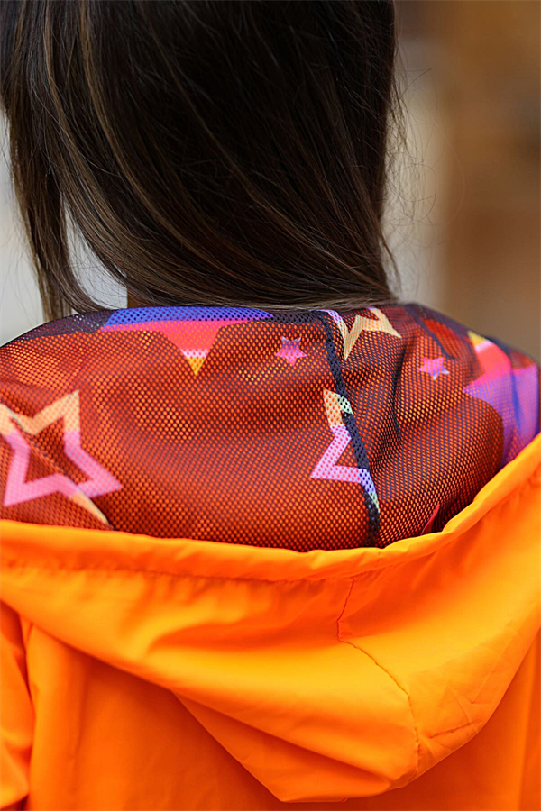 İçi renkli yıldız desenli astara sahip turuncu kapüşonlu ince yağmurluk.