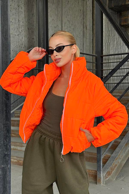 Dik yakalı, fermuarlı ve kısa kesim turuncu şişme mont.