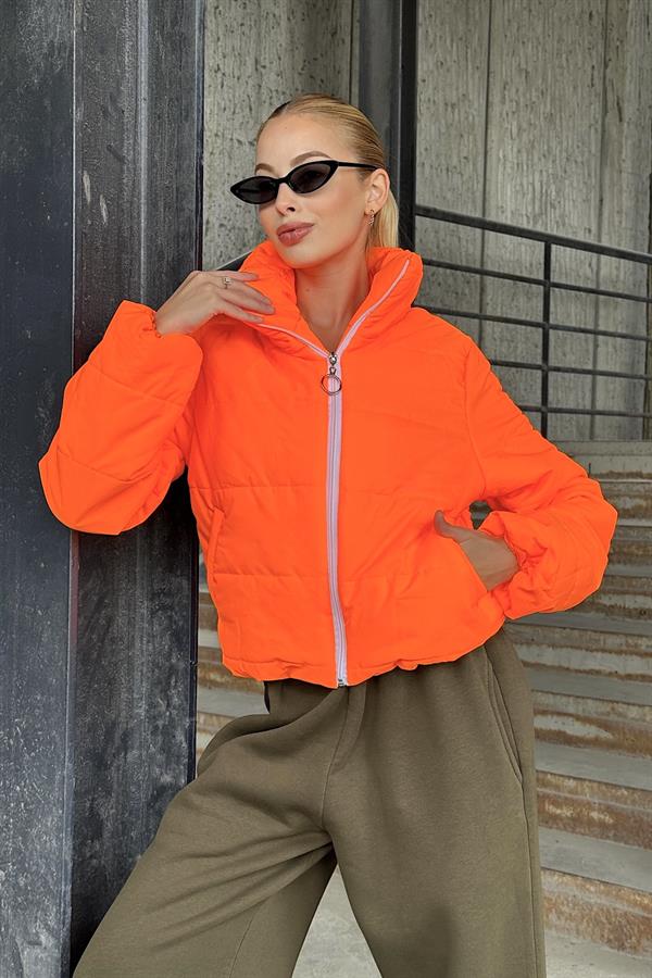 Dik yakalı, fermuarlı ve parlak turuncu renkte kısa şişme mont.